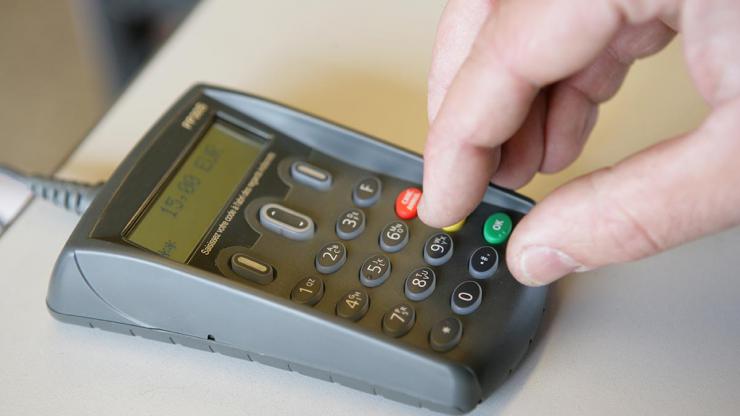 Personne entrant son code de carte bancaire sur un terminal de paiement lectronique