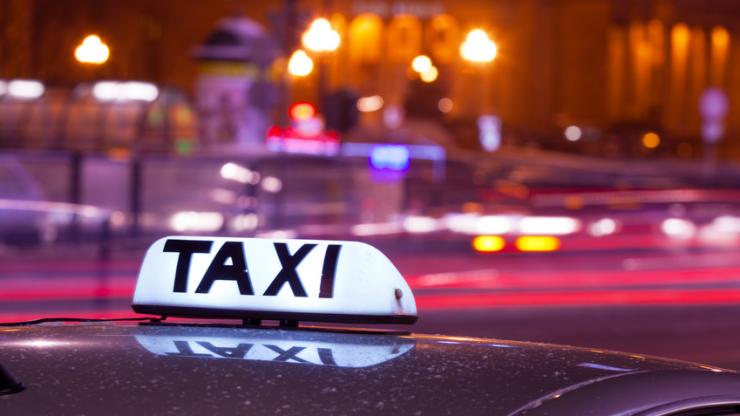 Enseigne de taxi dans une ville la nuit