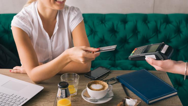 Femme payant par carte bancaire dans un caf