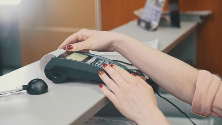 Femme effectuant un paiement par carte bancaire sur un terminal de paiement