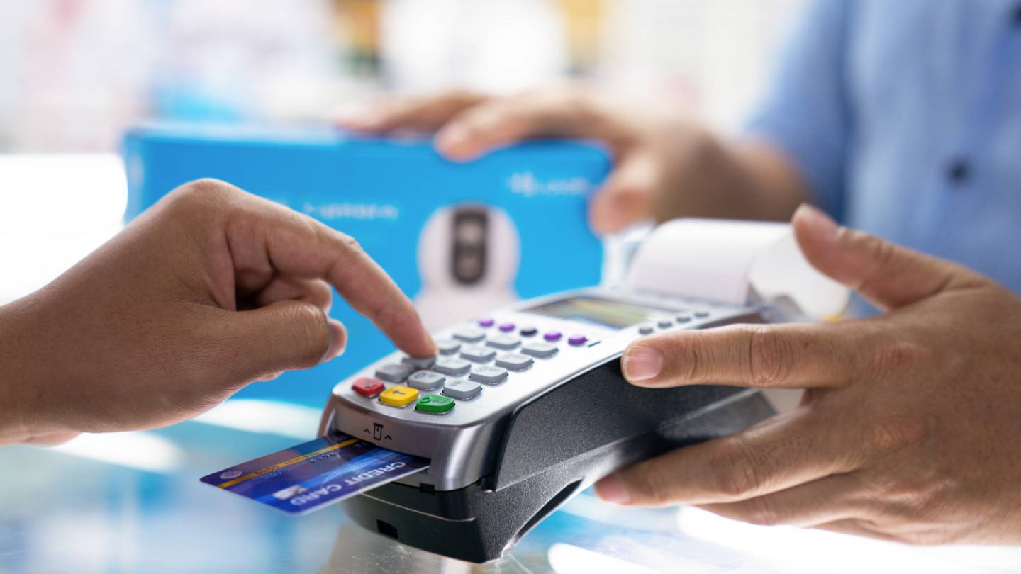 Consommateur tapant son code de carte bancaire
