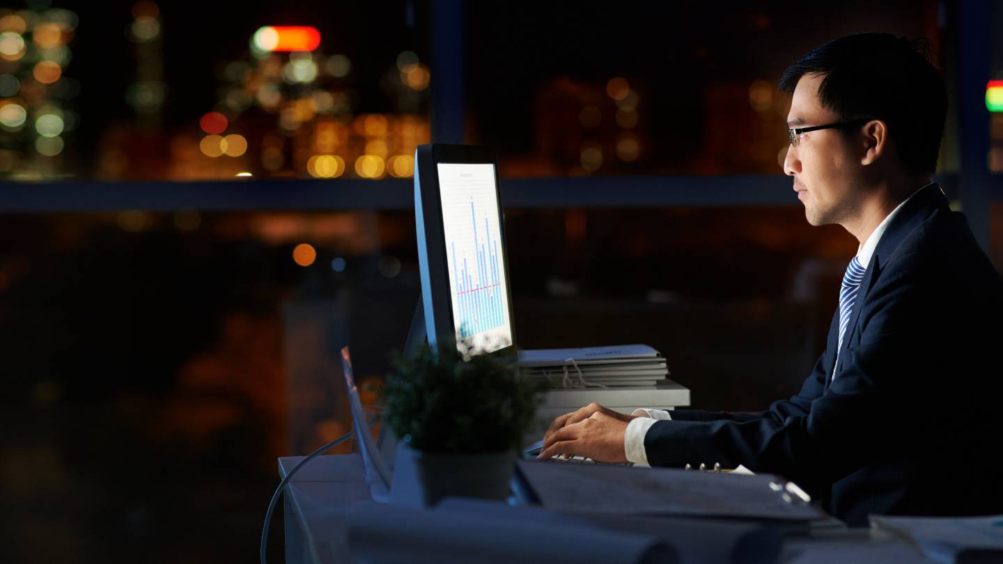 Homme en costume dans l'obscurit devant un cran d'ordinateur
