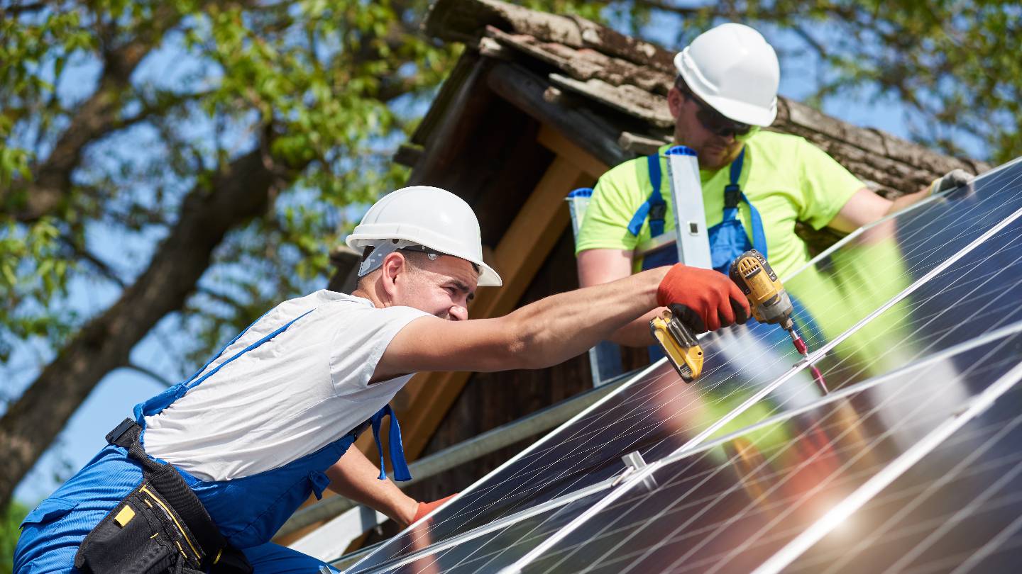 hommes installant des panneaux solaires sur un toit