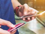 Un homme tient un mobile et une carte bancaire