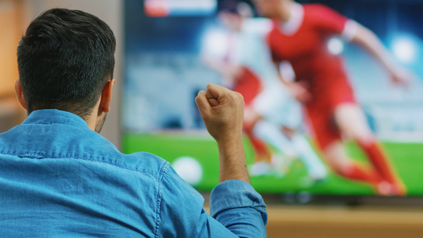 Un homme regarde du football  la tlvision