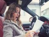 Femme lisant une facture au volant