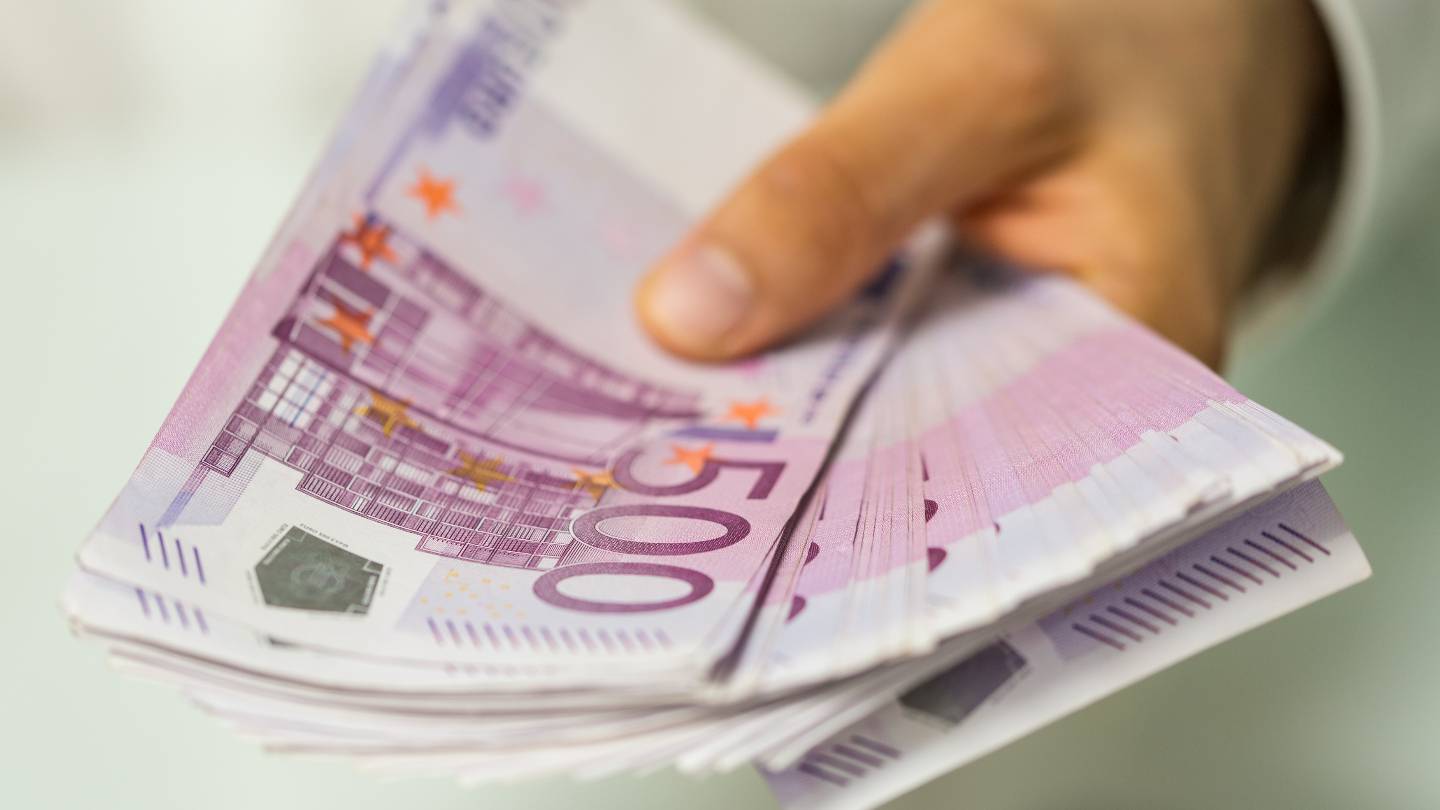 Un homme tient une liasse de billets de 500 euros