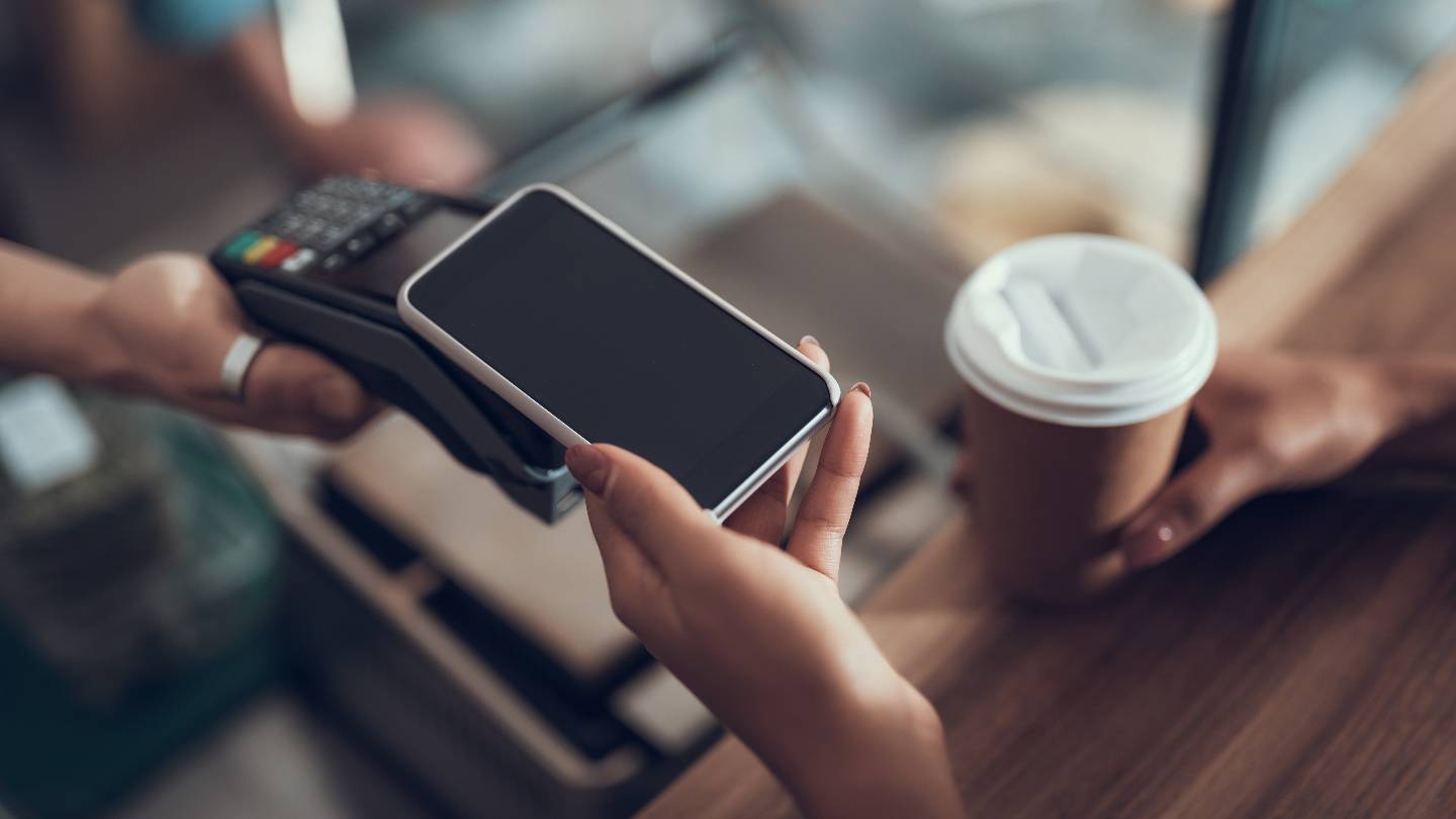Une femme paye son caf avec un smartphone