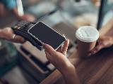 Une femme paye son café avec un smartphone