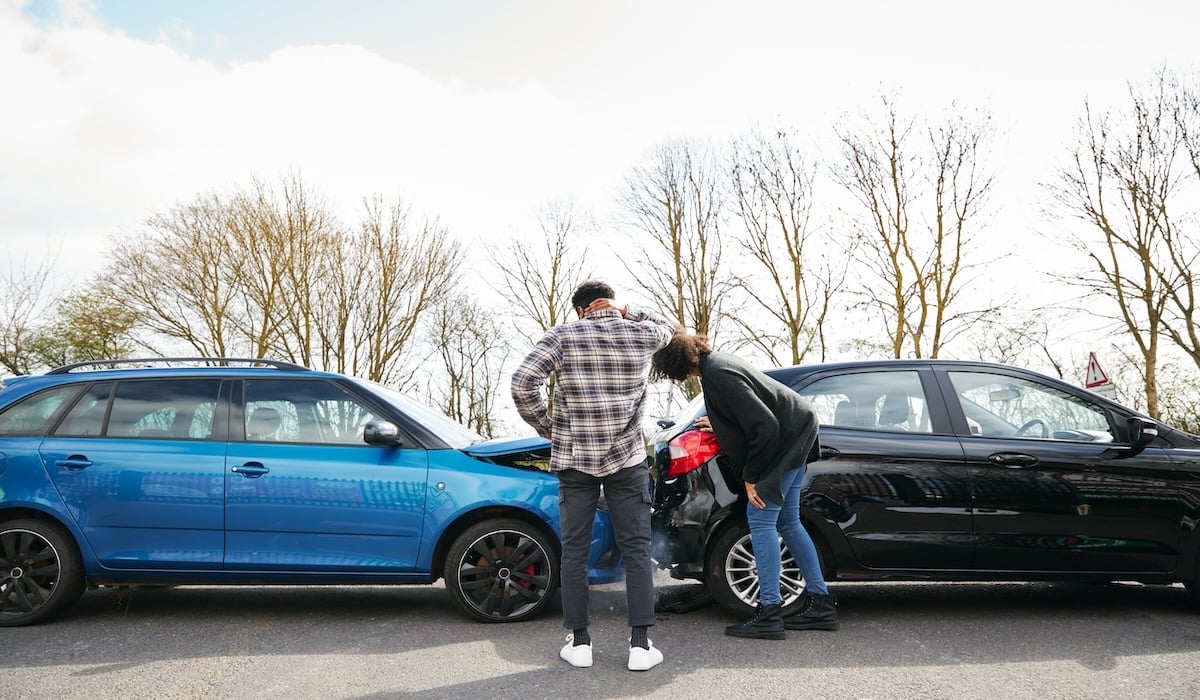 Deux automobilistes regardent deux voitures accidentes.
