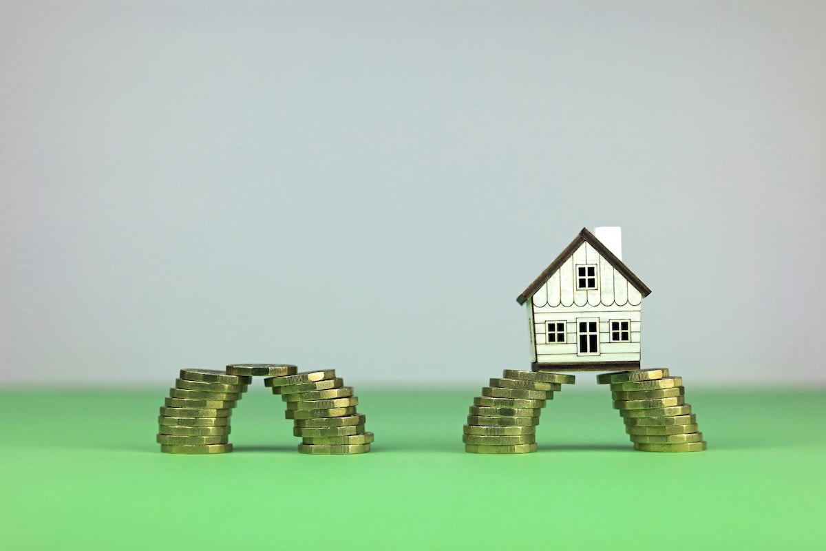 Deux piles de pices qui se rejoignent et une maison miniature.