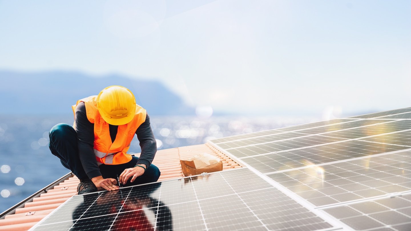 Quelqu'un installe des panneaux photovoltaques.