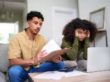 Deux personnes se questionnent devant des documents.
