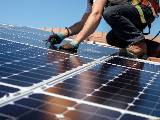 Un professionnel installe des panneaux photovoltaques sur un toit.