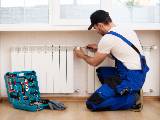 Un homme installe un thermostat sur un radiateur